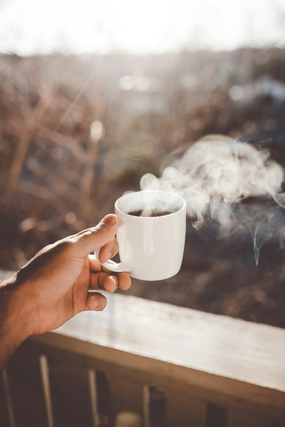 Persona che tiene una tazza di caffè caldo